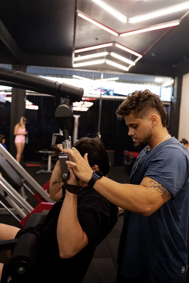 Gustavo Borba ajustando a pegada de um aluno em treino personalizado de costas na academia em Joinville